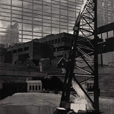 A tall, open scaffold-like structure dominates the foreground, with a series of low, concrete buildings piled onto each other, in front of a glass facade that fills the background. 