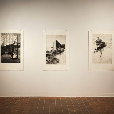 Three large monochromatic black and white etchings, showing a series of tall, vertically oriented structures. As the prints are read left to right, the foundations of the structures become increasingly precarious.