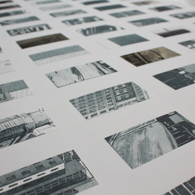 A grid of small glimpses of architectural details like windows, streetlights, concrete surfaces, and doorways, printed in silvery-blue and arranged on a white sheet of paper.