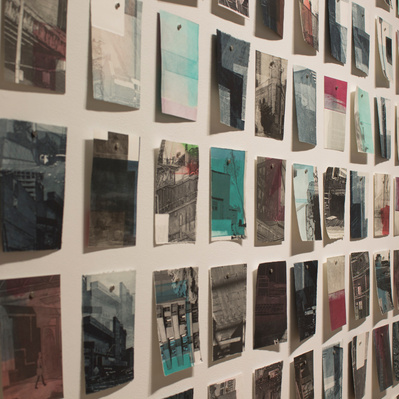A large grid of colourful prints of architectural details pinned to a white wall.