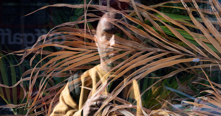 Self-portrait of Tom Gifford showing his reflection in a shop window on Hampstead Road, London.