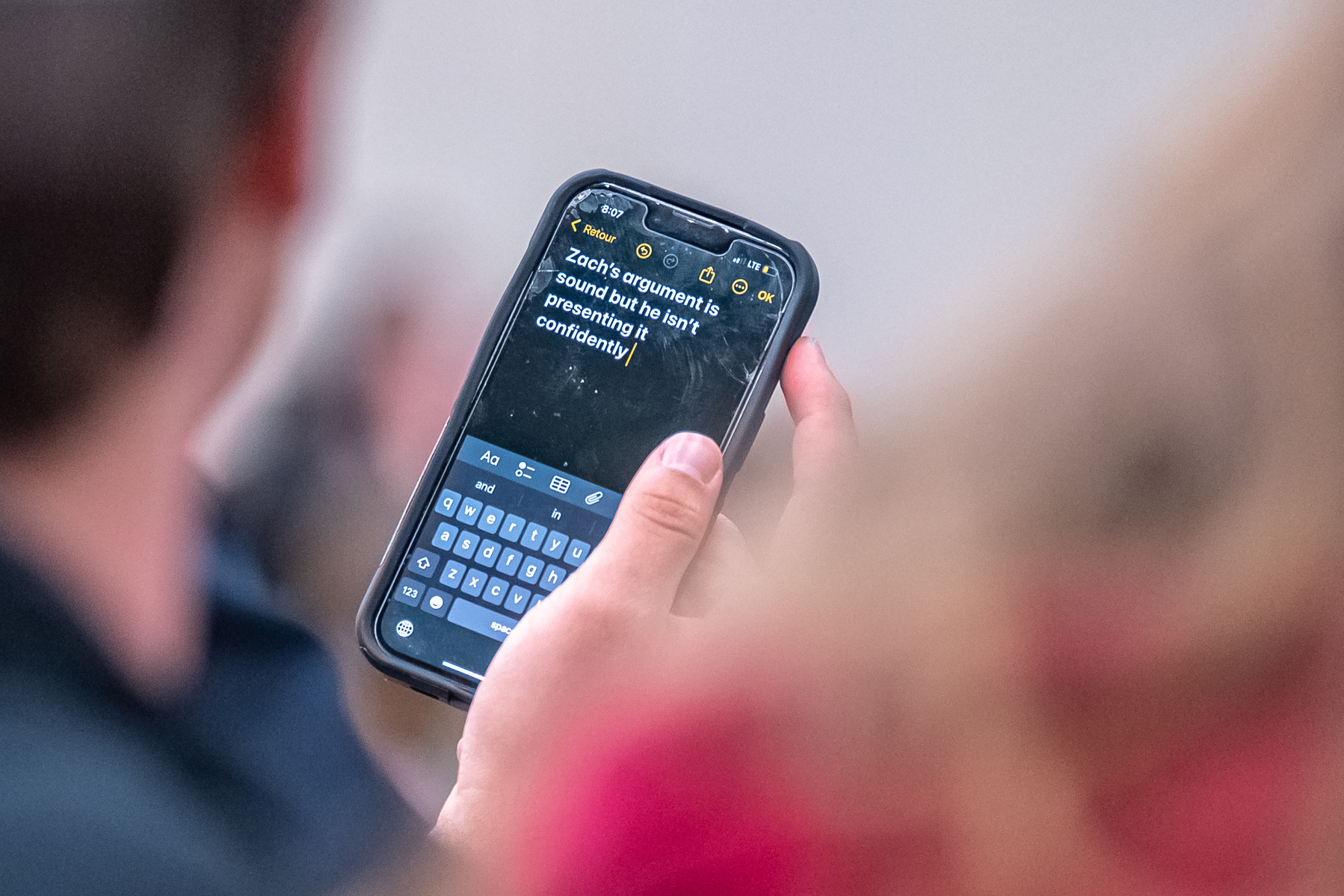A phone message is shared between spectators during a debate between Michigan State University Democrats and College Republicans at Broad Business College in East Lansing, Michigan on April 15, 2025.