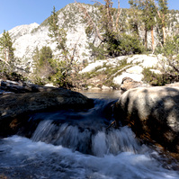 Waterfall and rocks with a mountain behind