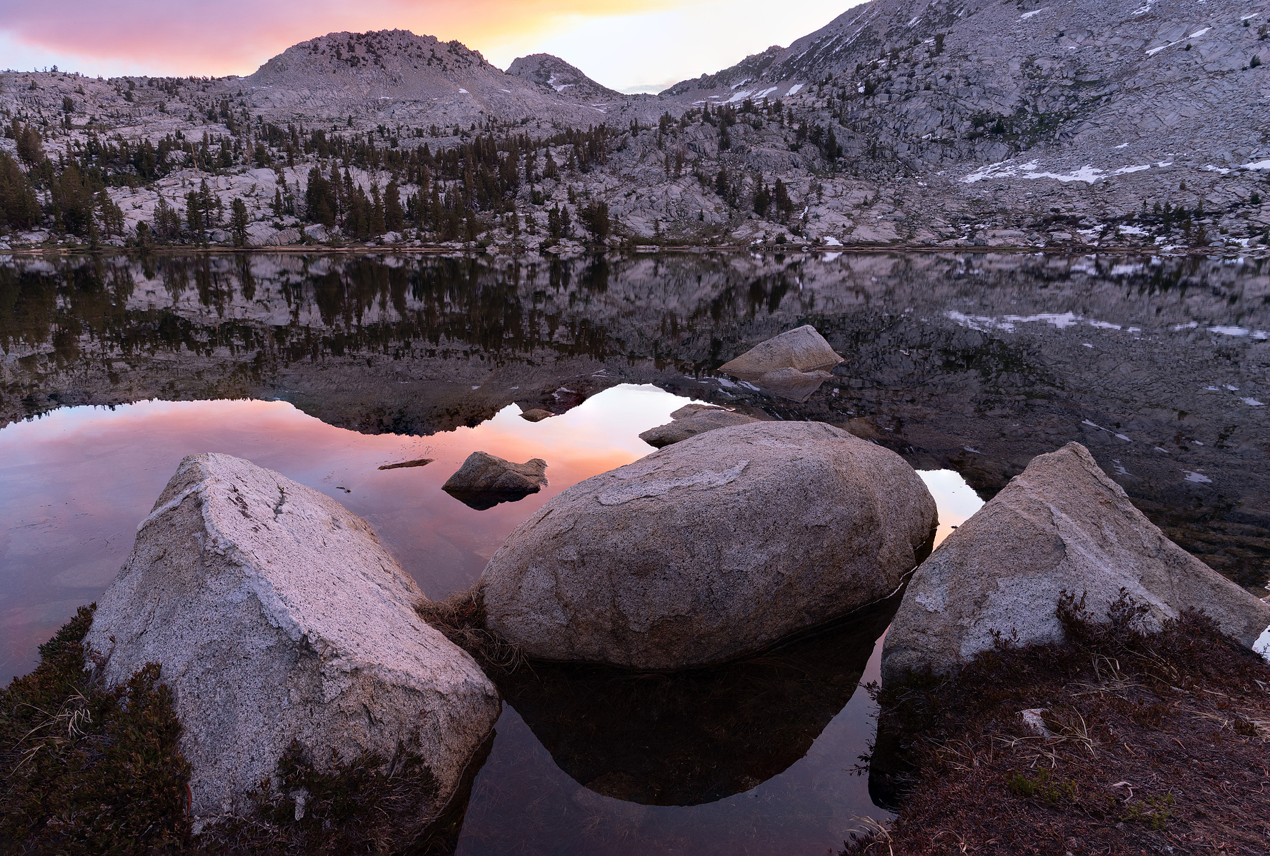 Sunrise over Grouse Lake with boulders in the foreground