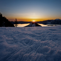 The sun rises over the top of Wizard Island