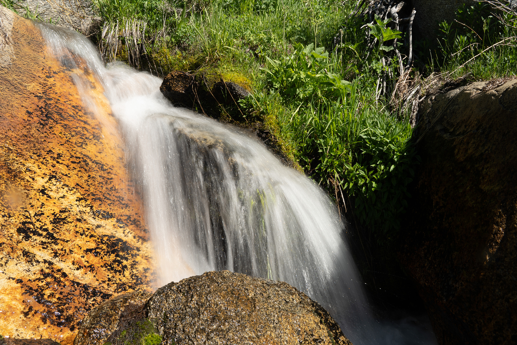 A beautiful waterfall flowing over copper colored rocks