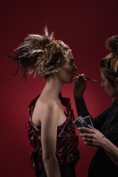 Fashion photo with Spartacus-themed styling and intricate hair design in an artistic studio setting.