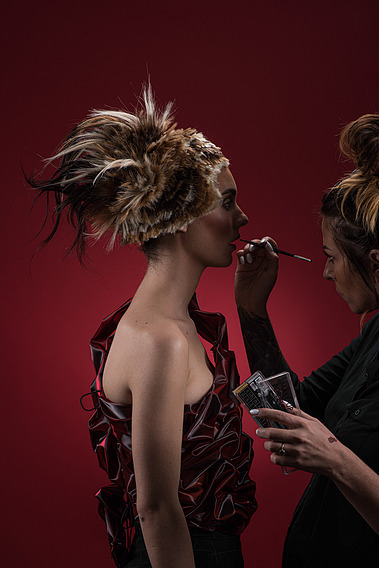 Fashion photo with Spartacus-themed styling and intricate hair design in an artistic studio setting.