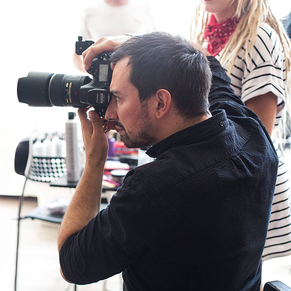 Creative photo shoot combining modern fashion and Spartan influence, with bold hair design in an art studio.