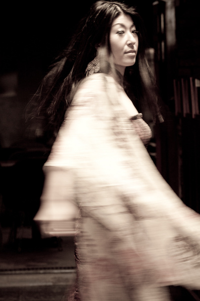 Young Japanese woman with shiny long hair moving around in kimono