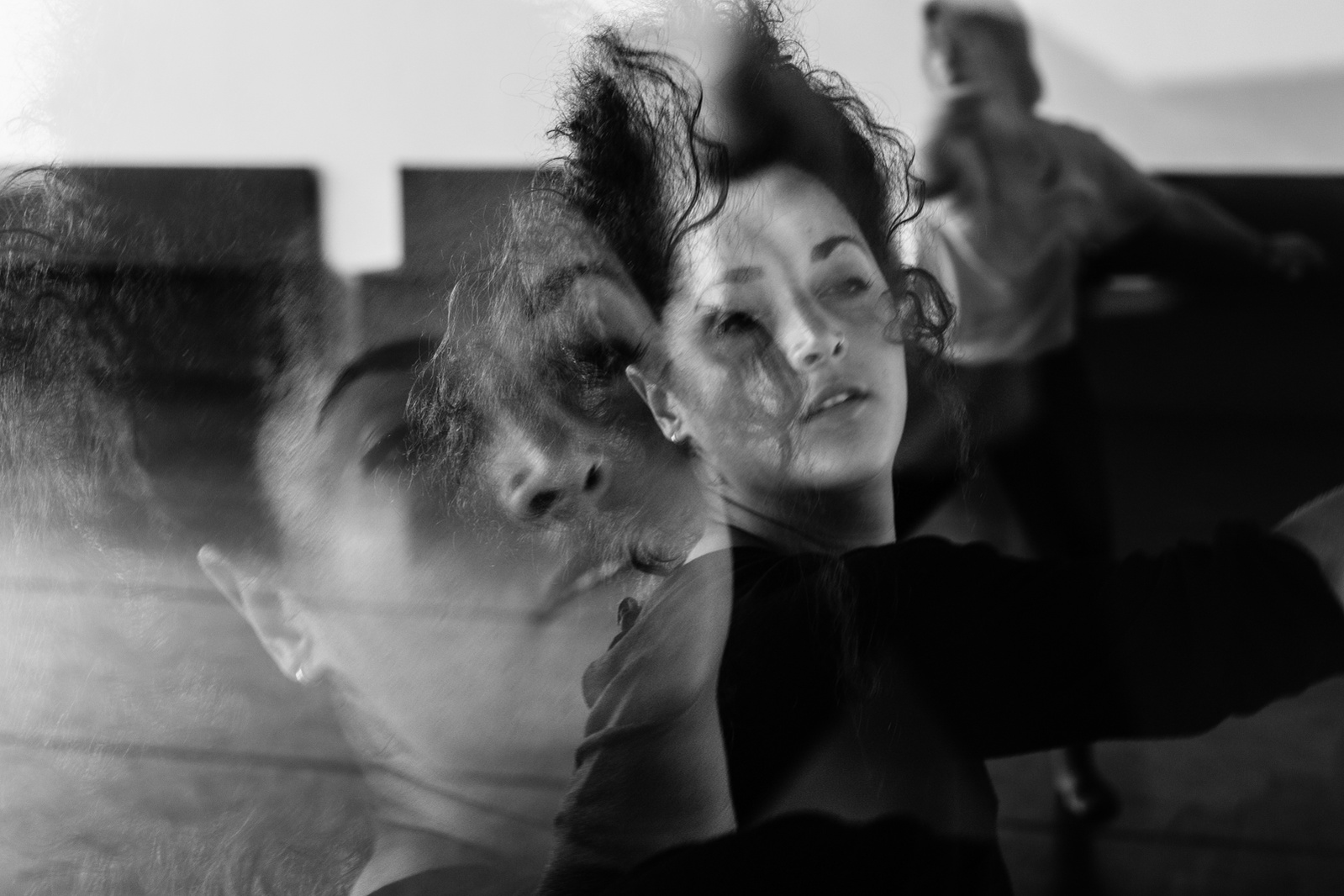 Double exposure close up of a dancer in motion with waving hair in front of her face