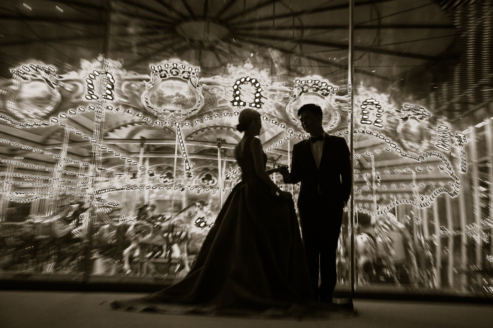 Silhouette of wedding couple with lights of  merry-go-around
