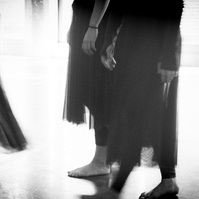 Detail of dancer's skirts moving in soft light in a dance studio