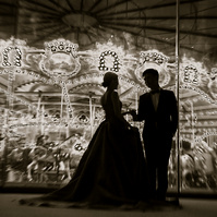 Silhouette of wedding couple with lights of  merry-go-around
