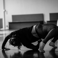 Young woman dancing bending over her back while other dancer watches her