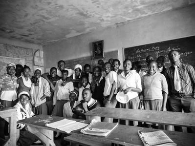 A group of students in Haiti pose for a portrait in their classroom