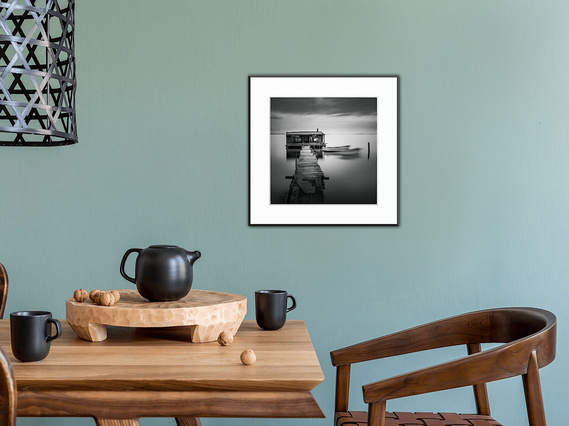 Complement your black tableware with this fine art piece of an old fishing shack and its boats wobbling about in the water.