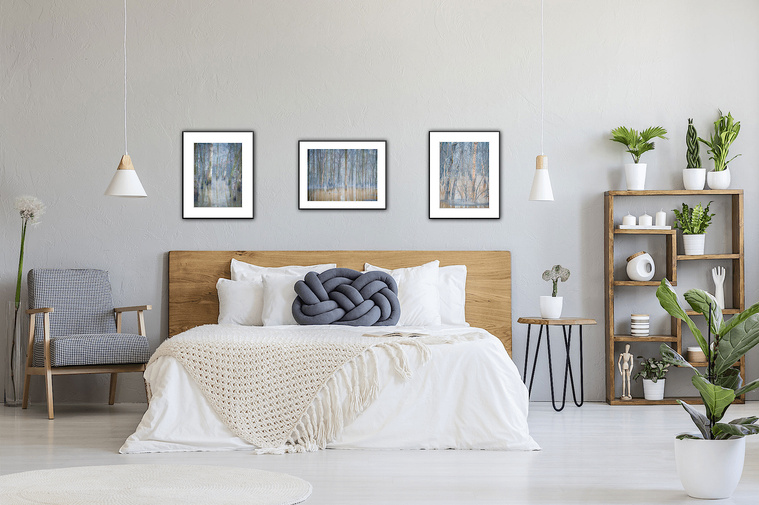 Bedrooms require tranquility. A king sized bed is wide enough to accommodate a set of three pictures. Use one horizontal frame bookended by two verticals to add interest. This set of three has a gray blue overtone of early morning fog so they work well in