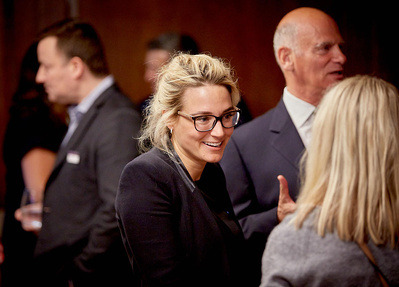 Year end function photographer for corporate events in London. Natural photo of business people involved in a conversation during a party.