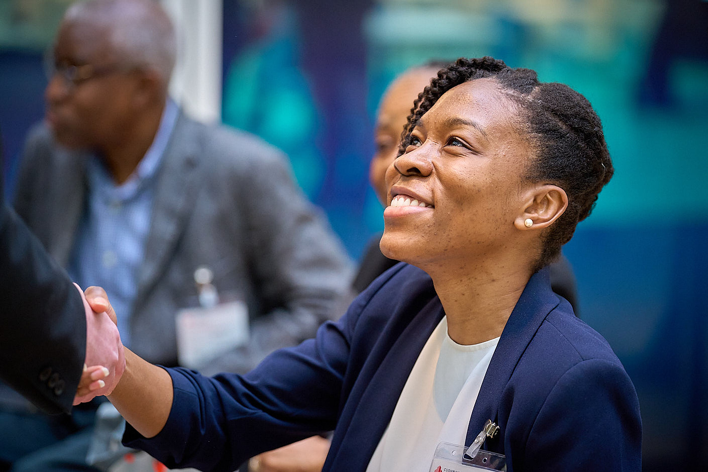 Business woman photographed at a tech event, shaking hands at CMC Markets in London.