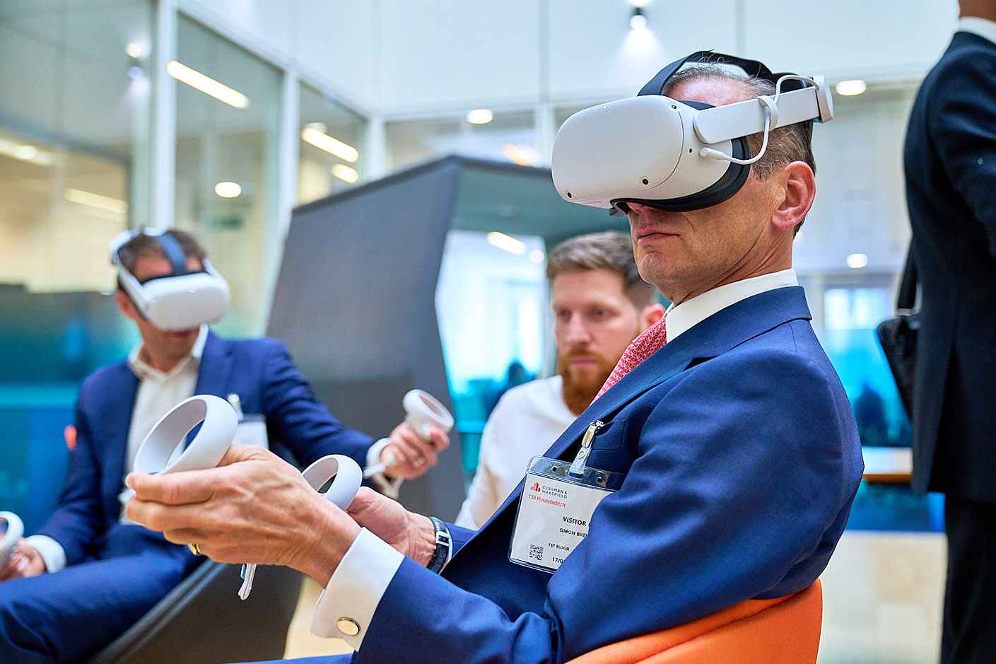 Event photography of business people enjoying VR demonstration while wearing headsets, at CMC Markets.