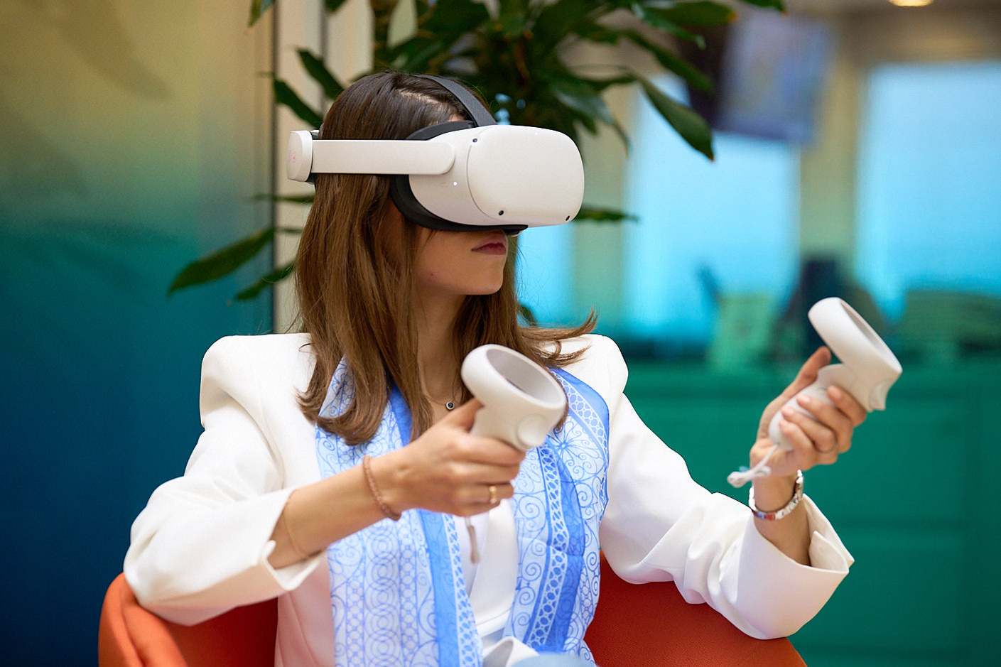 Event photography of a woman in business enjoying VR demonstration while wearing headsets, at CMC Markets.
