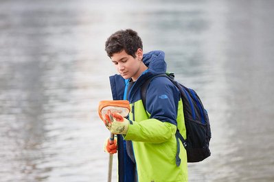 Public environmental PR photography by Josh Caius, for Thames21/Tideway in London. Children and adults picking litter around the Thames as part of a corporate day off event to help the local community.