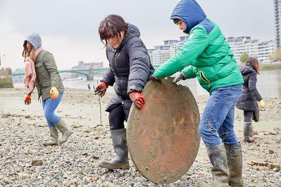 Public environmental PR photography by Josh Caius, for Thames21/Tideway in London. Children and adults picking litter around the Thames as part of a corporate day off event to help the local community.