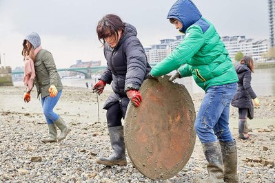 Public environmental PR photography by Josh Caius, for Thames21/Tideway in London. Children and adults picking litter around the Thames as part of a corporate day off event to help the local community.