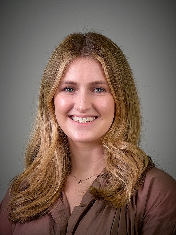 Female headshot photography for businesses. Plain background head shots taken in the office.
