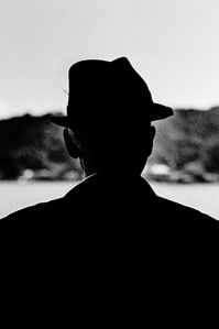 A man on the ferry to Miyajima. 
From the photographic series "In Praise of Shadows". Shot on black and white film by photographer Matthew Fleming. 