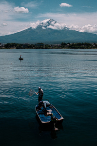 Men fish from small boats on Lake Kawaguchi (Kawaguchiko), with Mt. fuji in the background. 
Photograph from the series Forbidden Colours by Matthew James Fleming. Taken with a Leica M6 and Kodak Portra 400.
