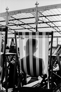 Photograph from the series To Live and Die in Lancashire: The Chapel of the Roses by Matthew James Fleming. Taken with a Leica M6 and Ilford HP5 35mm film. 
A sunbathers shadow is cast upon a striped deckchair, Blackpool.