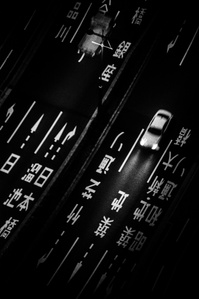 Cars moving on the roads at night in Shiodome, Tokyo. 
From the photographic series "In Praise of Shadows". Shot on black and white film by photographer Matthew Fleming. 