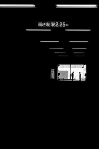 Two silhouettes at the end of a tunnel in Tokyo. 
From the photographic series "In Praise of Shadows". Shot on black and white film by photographer Matthew Fleming. 