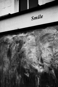 Photograph from the series To Live and Die in Lancashire: The Chapel of the Roses by Matthew James Fleming. Taken with a Leica M6 and Ilford HP5 35mm film. 
A closing down shop has the message, "Smile" on the cladding, Clitheroe.