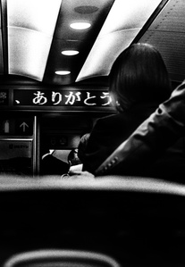 Commuters prepare to disembark a bullet train bound for Tokyo. 
From the photographic series "In Praise of Shadows". Shot on black and white film by photographer Matthew Fleming. 