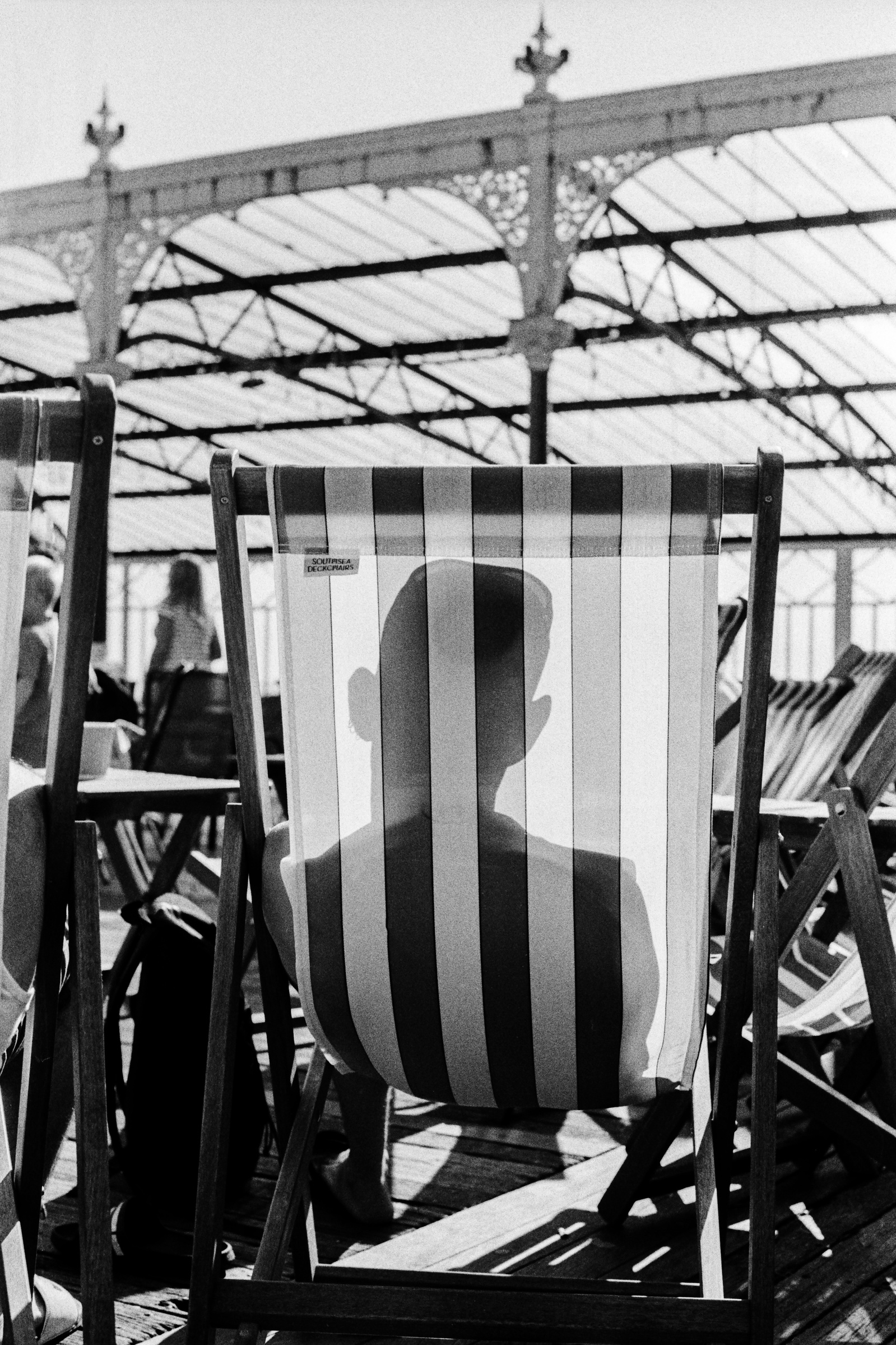 Sun lounger shadow, Blackpool North Pier, July 2019. Photographed by Matthew Fleming on 35mm Ilford HP5 film with a Nikon F100.
