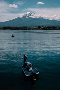 Men fish from small boats on Lake Kawaguchi (Kawaguchiko), with Mt. fuji in the background. 
Photograph from the series Forbidden Colours by Matthew James Fleming. Taken with a Leica M6 and Kodak Portra 400.