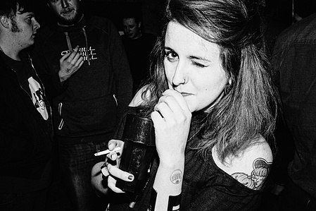 A woman winks at the photographer whilst drinking, Lancaster. 
Photograph from the series To Live and Die in Lancashire: Wet Paint by Matthew James Fleming. Taken with a Leica M6 and Ilford HP5 35mm film.