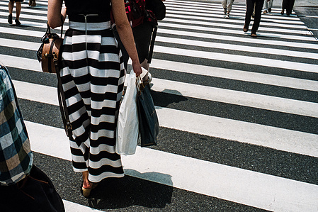 A woman in a striped skirt crosses one of Ginza's famous pedestrian crossings, Tokyo. 
Photograph from the series Forbidden Colours by Matthew James Fleming. Taken with a Leica M6 and Kodak Portra 800.