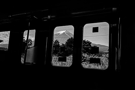 Fuji as visible through a train carriage doorway on the way to Fujikawaguchiko. 
From the photographic series "In Praise of Shadows". Shot on black and white film by photographer Matthew Fleming. 