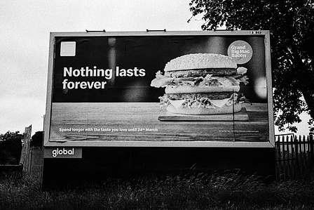 Photograph from the series To Live and Die in Lancashire: Goodbye Pork Pie Hat by Matthew James Fleming. Taken with a Leica M6 and Ilford HP5 35mm film. 
A billboard advertising a McDonalds burger with the caption "Nothing lasts forever" 