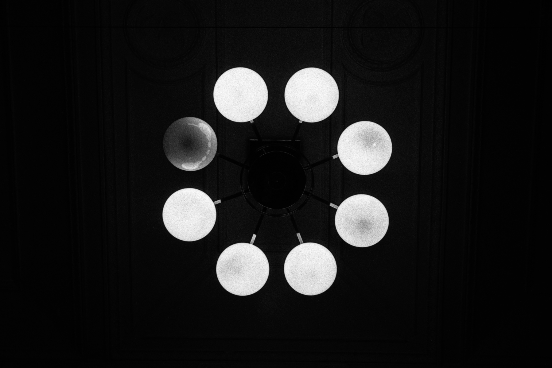 A broken lightbulb in a chandelier, Prague, January 2017. Photographed by Matthew Fleming on 35mm Ilford HP5 film with a Leica M6.