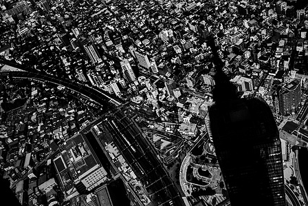 The Shadow of the Tokyo Skytree is cast over smaller buildings in Tokyo. 
From the photographic series "In Praise of Shadows". Shot on black and white film by photographer Matthew Fleming. 