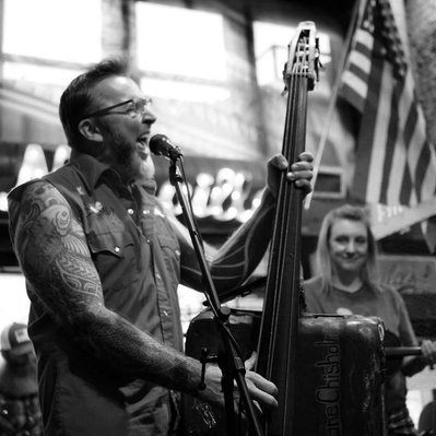 Black and white street photography of the french street photographer David Décamps representing a man playing guitar in a club in Nashville, USA.