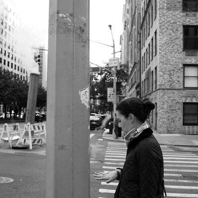 Black and white street photography of the french street photographer David Décamps representing a woman looking at her ring in New York City, USA.