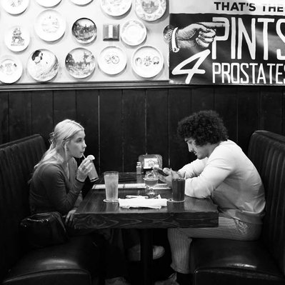 Black and white street photography of the french street photographer David Décamps representing a couple drinking a beer in a bar in Memphis, USA.