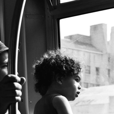 Black and white street photography of the french street photographer David Décamps representing a child looking at the window of a subway in New York City, USA.