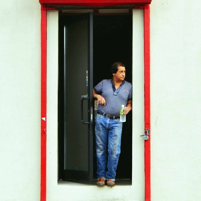 Street photography in colors of  the french street photographer David Décamps representing a man to the doorstep of a garage in New York City, USA.